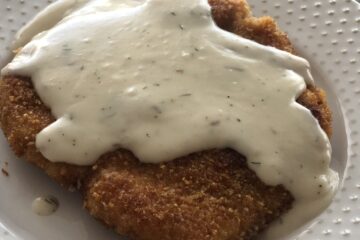 Breaded Pork Chops with Creamy Dill Sauce on a plate