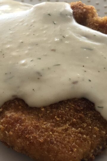 Breaded Pork Chops with Creamy Dill Sauce on a plate