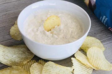 Clam Dip in a bowl with potato chips surrounding it
