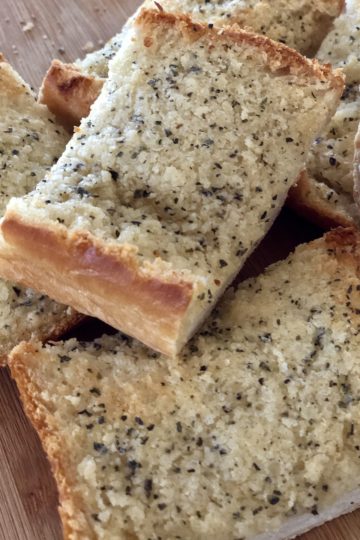 Slices of garlic bread that is baked and browned.
