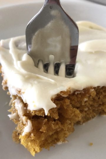 A piece of Pumpkin Bars with a fork poked in the cake ready to eat