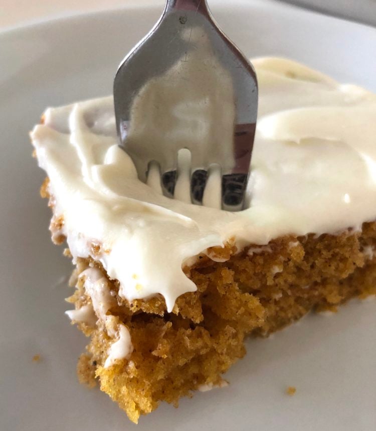 A piece of Pumpkin Bars with a fork poked in the cake ready to eat