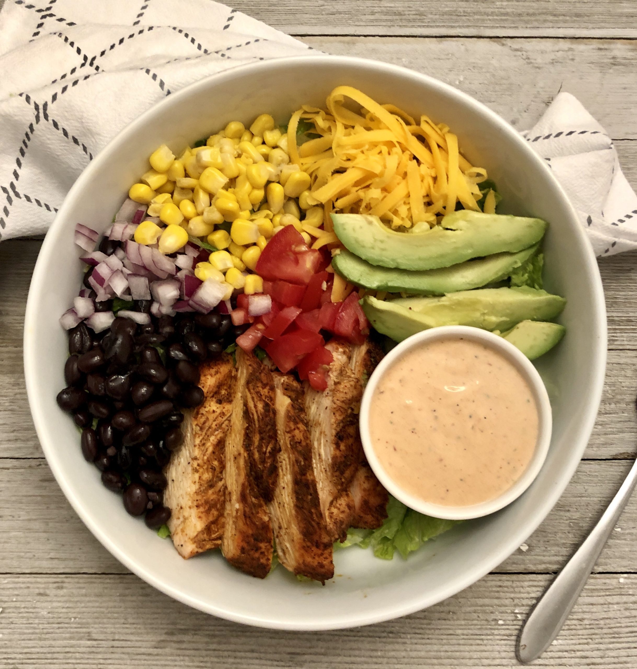 The BEST Salad - Grilled chicken, black beans, sweet corn, red onion, shredded cheese, tomatoes, avocado, tortilla strips all on crispy romaine lettuce with a tangy BBQ ranch dressing!