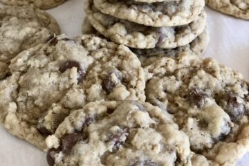 The BEST Oatmeal Chocolate Chip Cookies in a stack and some scattered around the stack