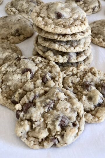 The BEST Oatmeal Chocolate Chip Cookies in a stack and some scattered around the stack