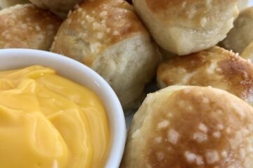soft pretzels bites with coarse salt sprinkled on top and a small dish of cheddar cheese dipping sauce