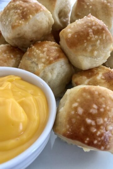 soft pretzels bites with coarse salt sprinkled on top and a small dish of cheddar cheese dipping sauce