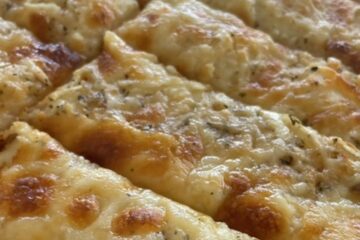 Close up shot of slices of Italian Cheese Bread with melty cheese on top