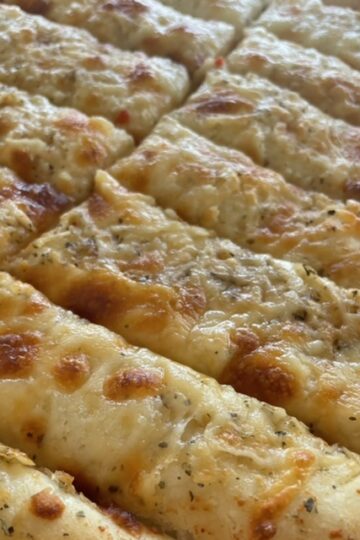 Close up shot of slices of Italian Cheese Bread with melty cheese on top