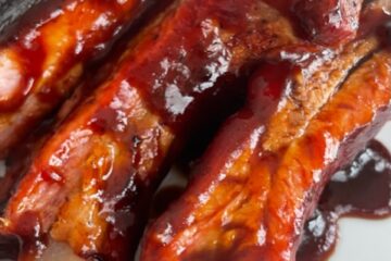 Up close shot of bbq baby back ribs with dripping bbq sauce