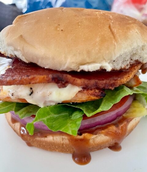 Grilled chicken sandwich with bbq sauce, tomato, lettuce, onion, pickles and bacon.