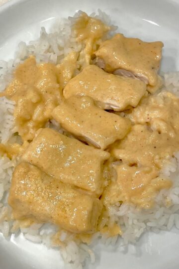 Creamy chicken bake with cut up chicken served over white rice on a plate