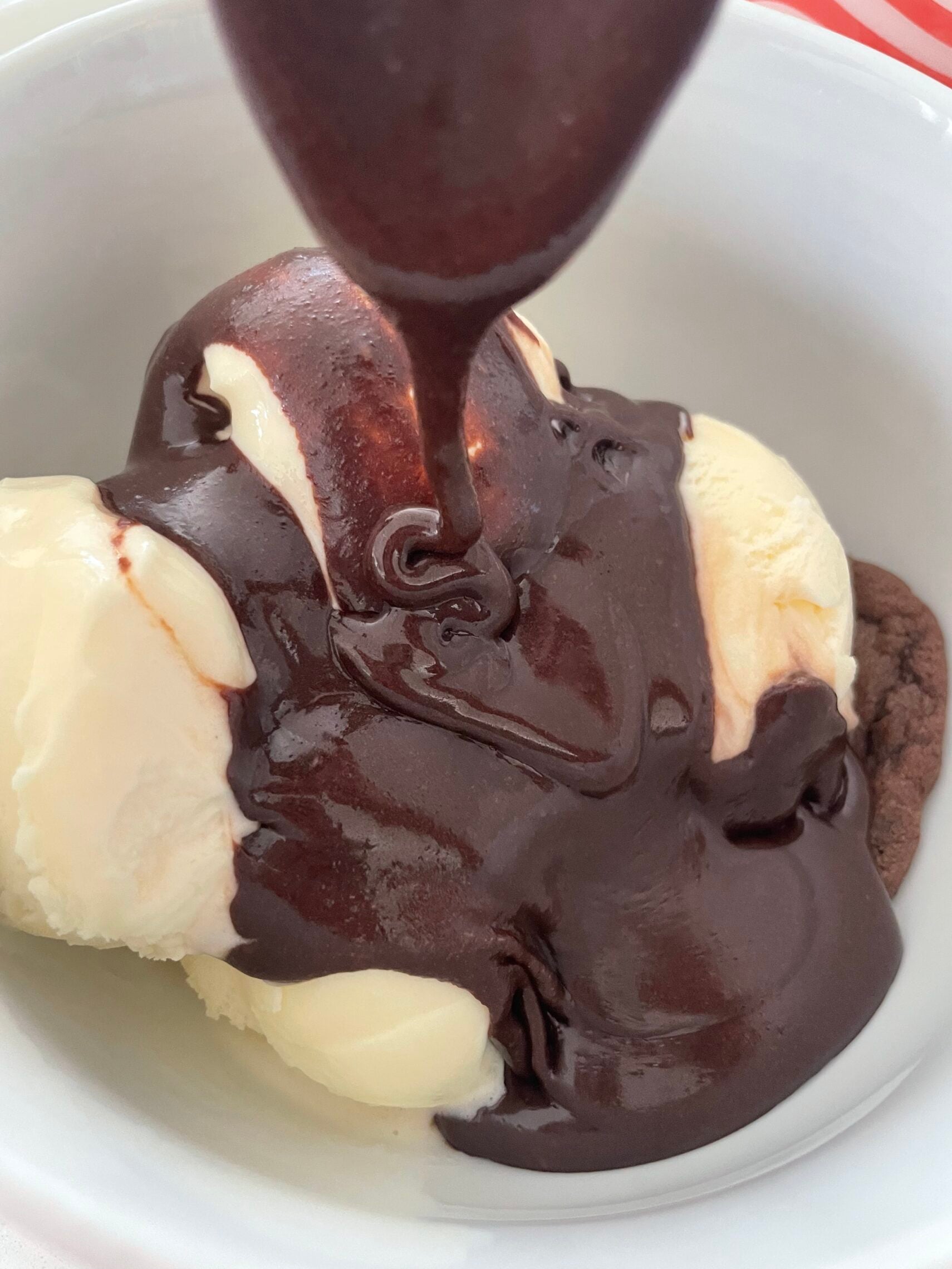 Old Fashioned Chocolate Sauce being poured on top of vanilla ice cream